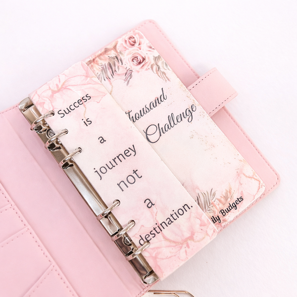 Pink planner with floral design and motivational quote on a white background