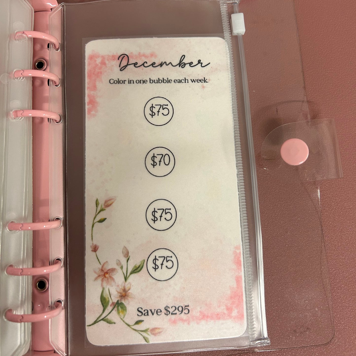 Planner with a clear sleeve and pink rings on a brown background