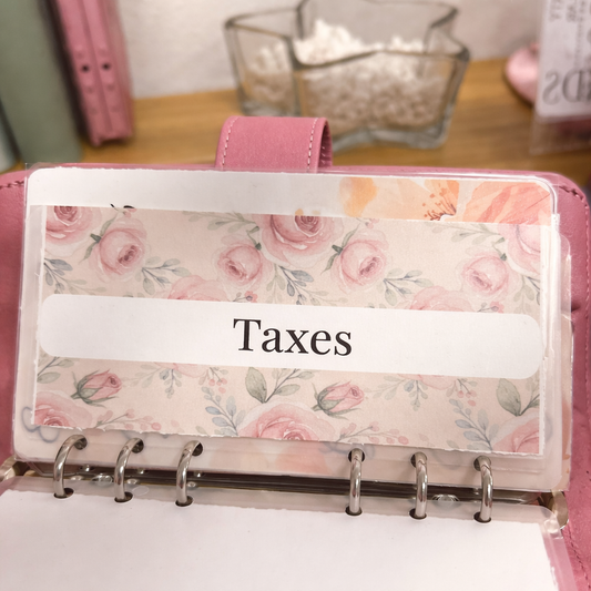 Floral planner with a 'Taxes' label on a desk