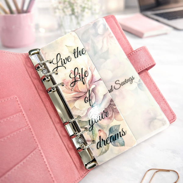 Pink planner with floral design and text on a desk