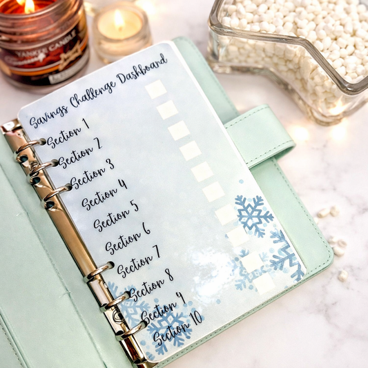 Planner with 'Savings Challenge Dashboard' on a decorative surface with candles and beads.
