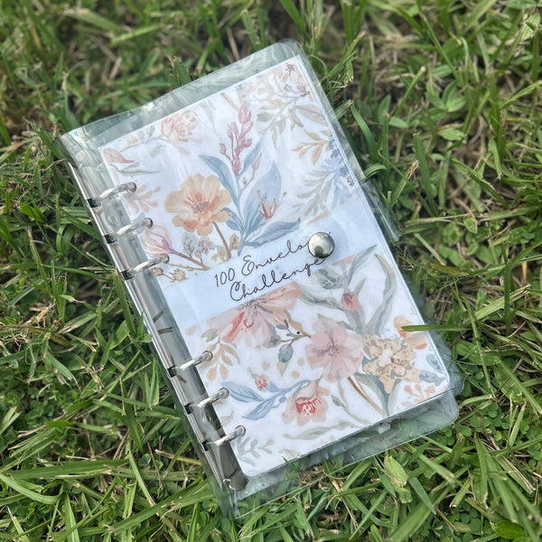 Floral notebook on grass with 100 envelope binder. 