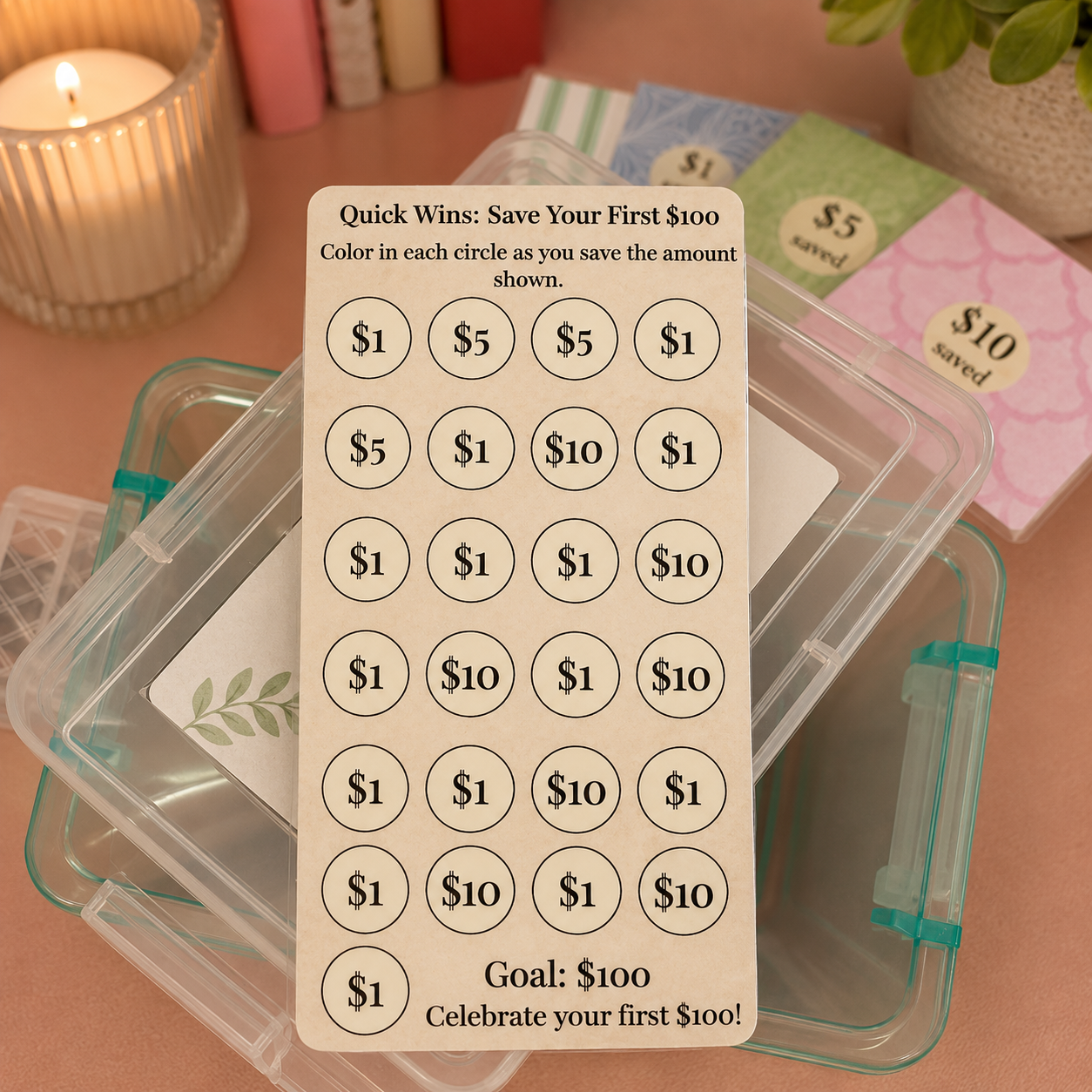 A beige plastic savings tracker card with circular price labels and text reading 'Quick Wins: Save Your $100' sits on top of a clear plastic storage container. Other matching cards in different colors are partially visible in the background on a pink surface.