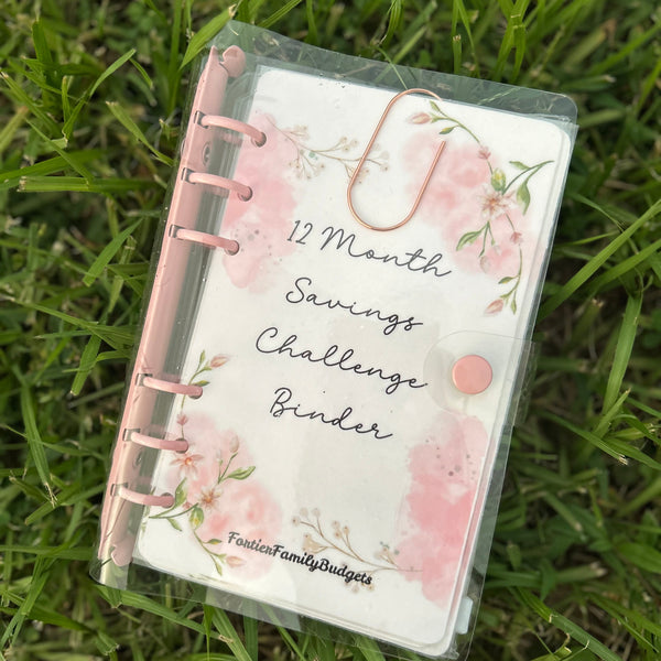 12 Month Savings Challenge Binder with floral design on grass