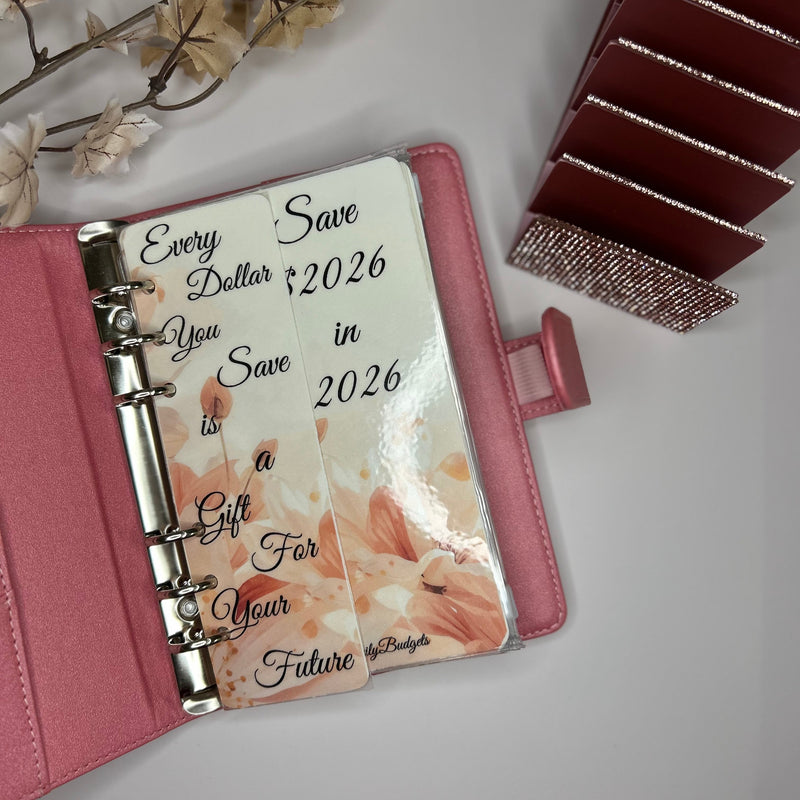 Pink planner with floral design and text on a light gray background