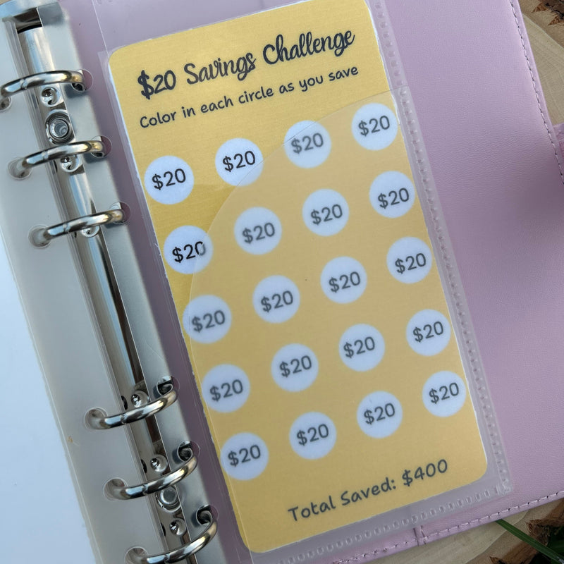 Purple planner with a yellow savings challenge card featuring $20 savings goals.