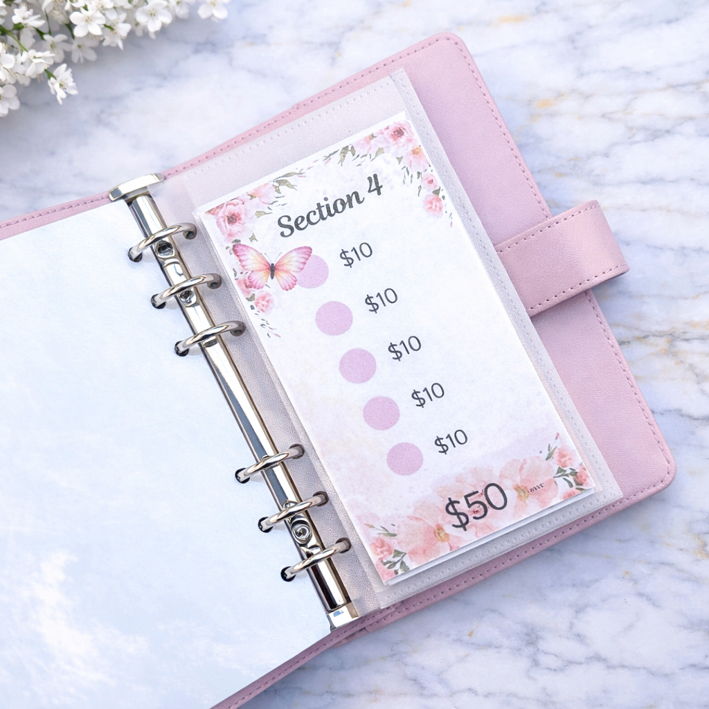 Pink planner with floral design on a marble surface