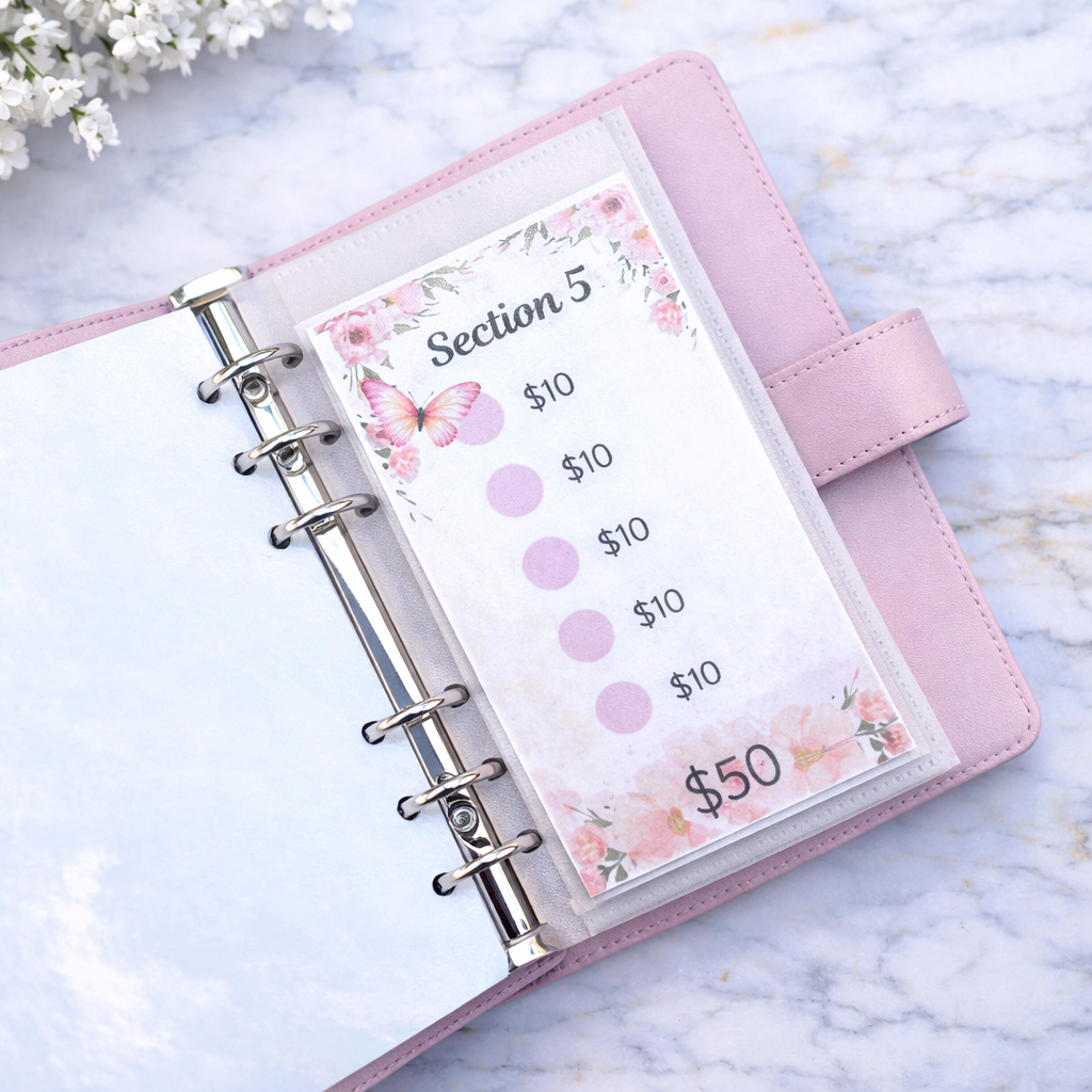 Pink planner with floral design on a marble surface