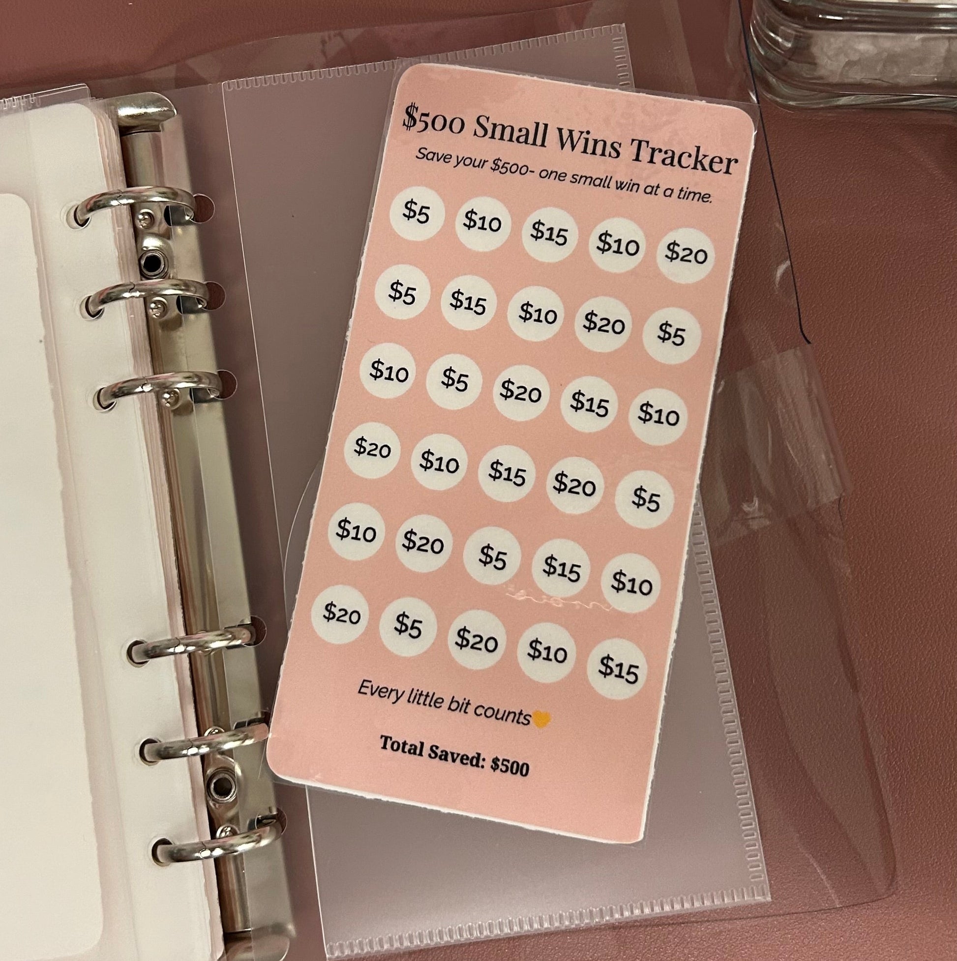 Small wins tracker card inside a planner on a brown surface