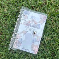 Clear planner with floral designs on grass