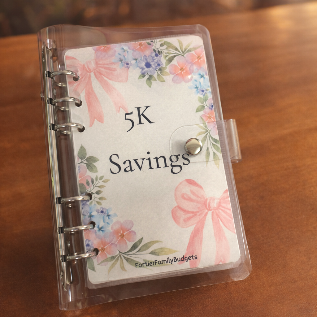 Small notebook with floral design and '5K Savings' text on a wooden surface