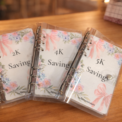 Three floral-themed savings trackers labeled 2K, 4K, and 5K on a wooden surface.
