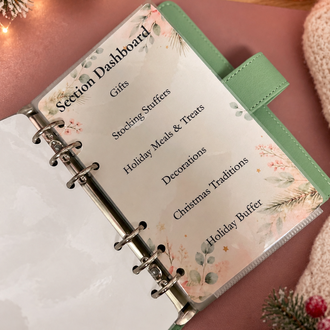 A mint green ring-bound planner binder shown open on a dusty pink surface, with a printed section dashboard page visible inside. The page lists categories such as Gifts, Stocking Stuffers, Holiday Meals & Treats, Decorations, Christmas Traditions, and Holiday Buffer.