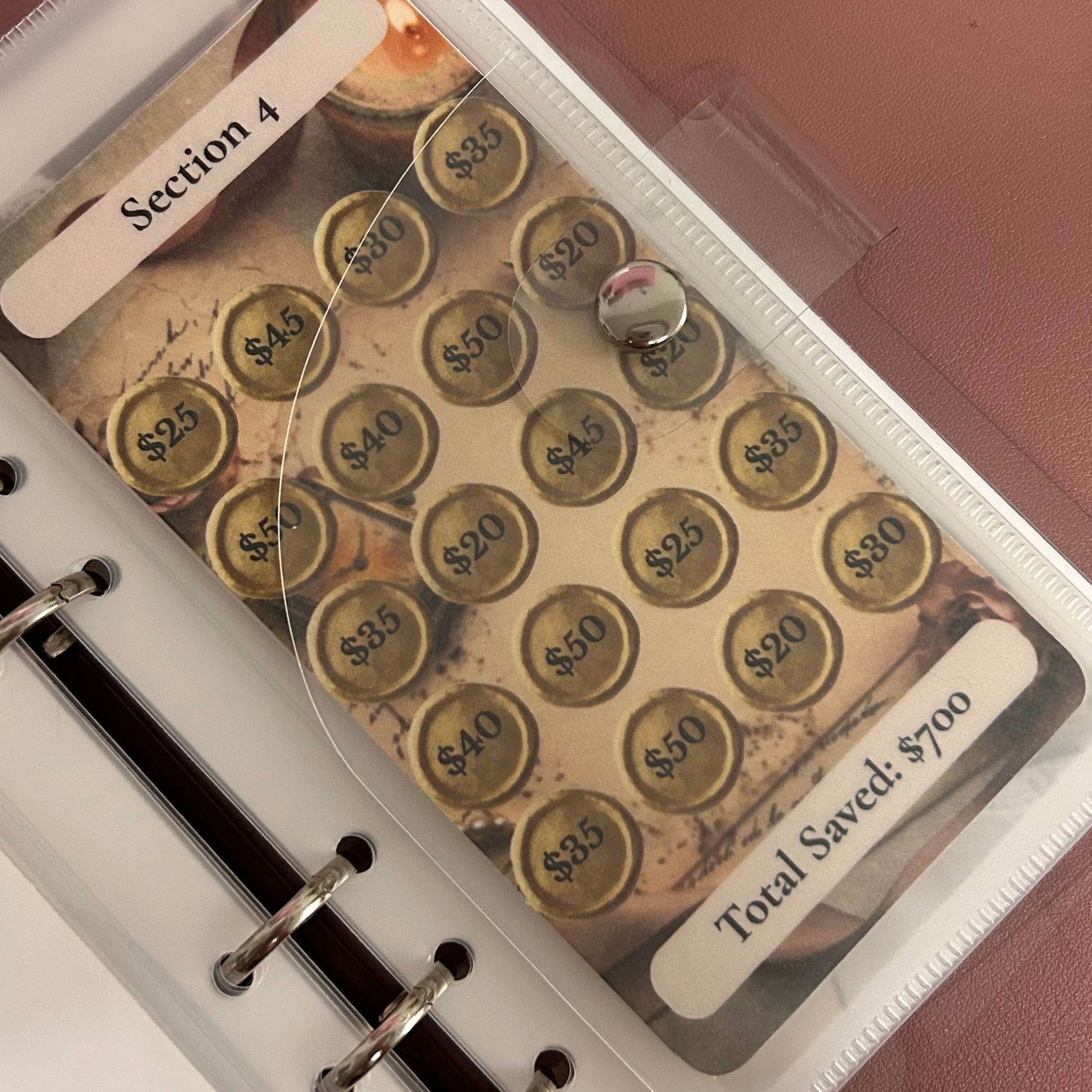 Savings tracker with coins and a pen on a white surface