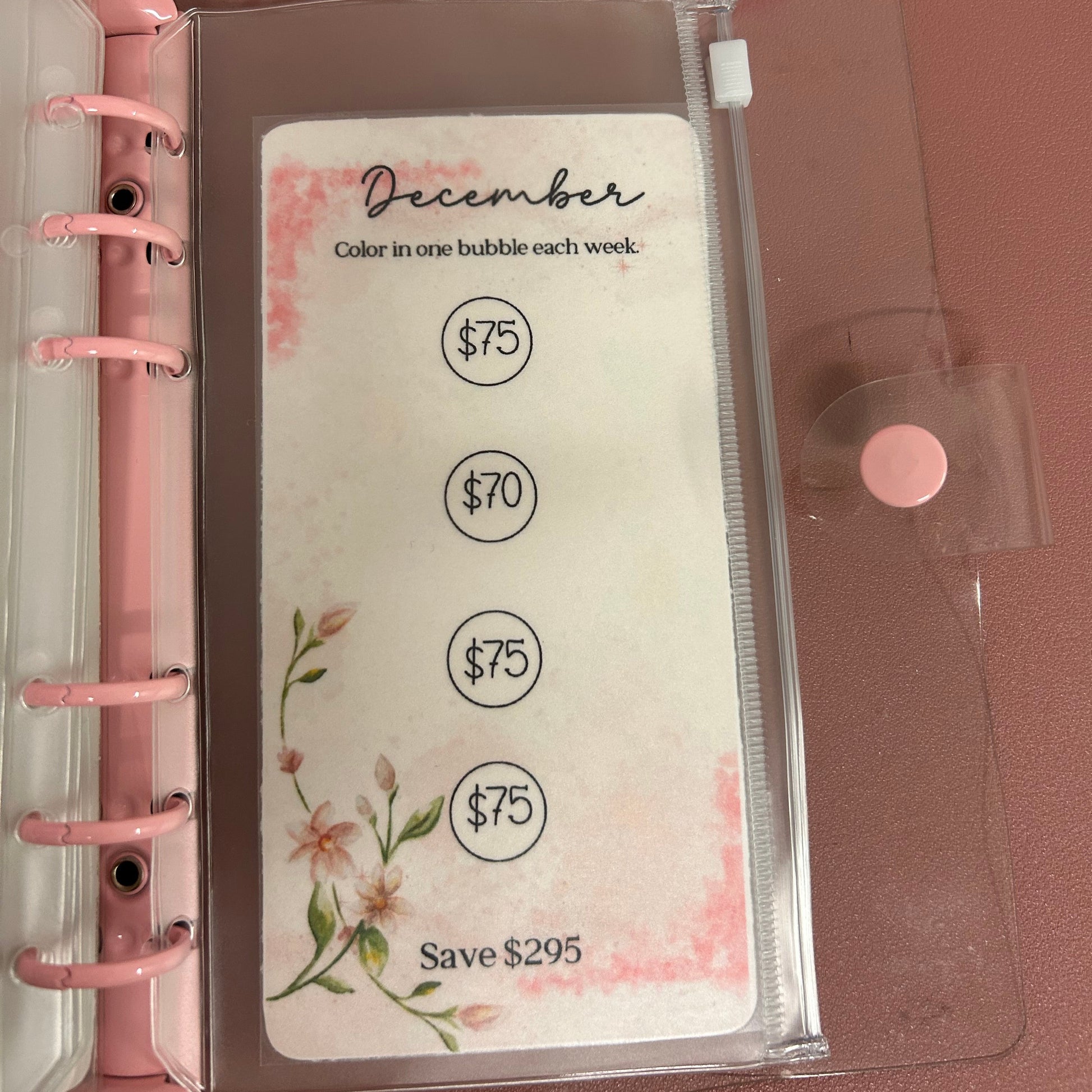 Planner with a clear sleeve and pink rings on a brown background