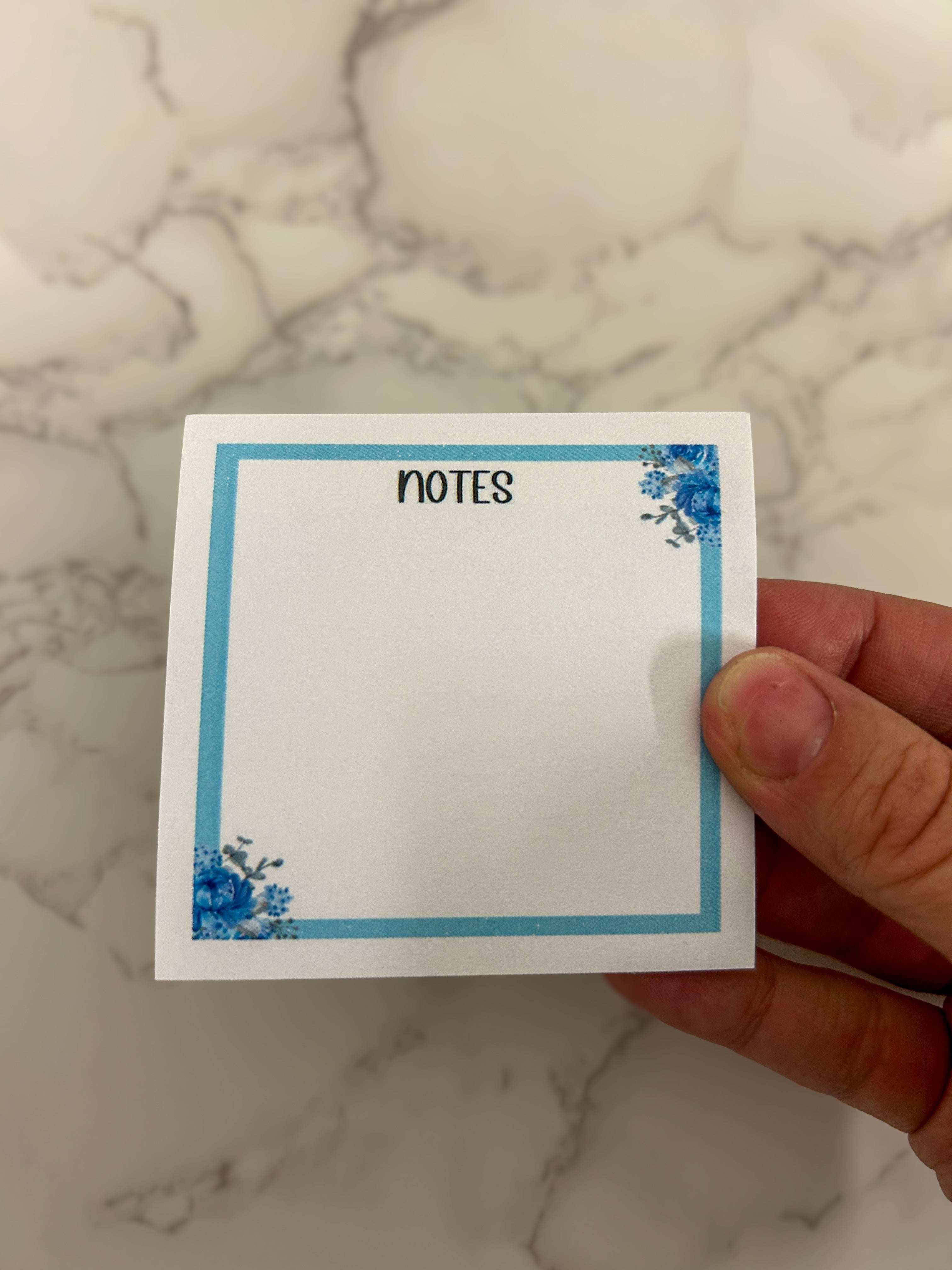 Blue floral sticky notes with elegant flower patterns, ideal for jotting down reminders, to-do lists, or adding a touch of charm to your workspace or planner.