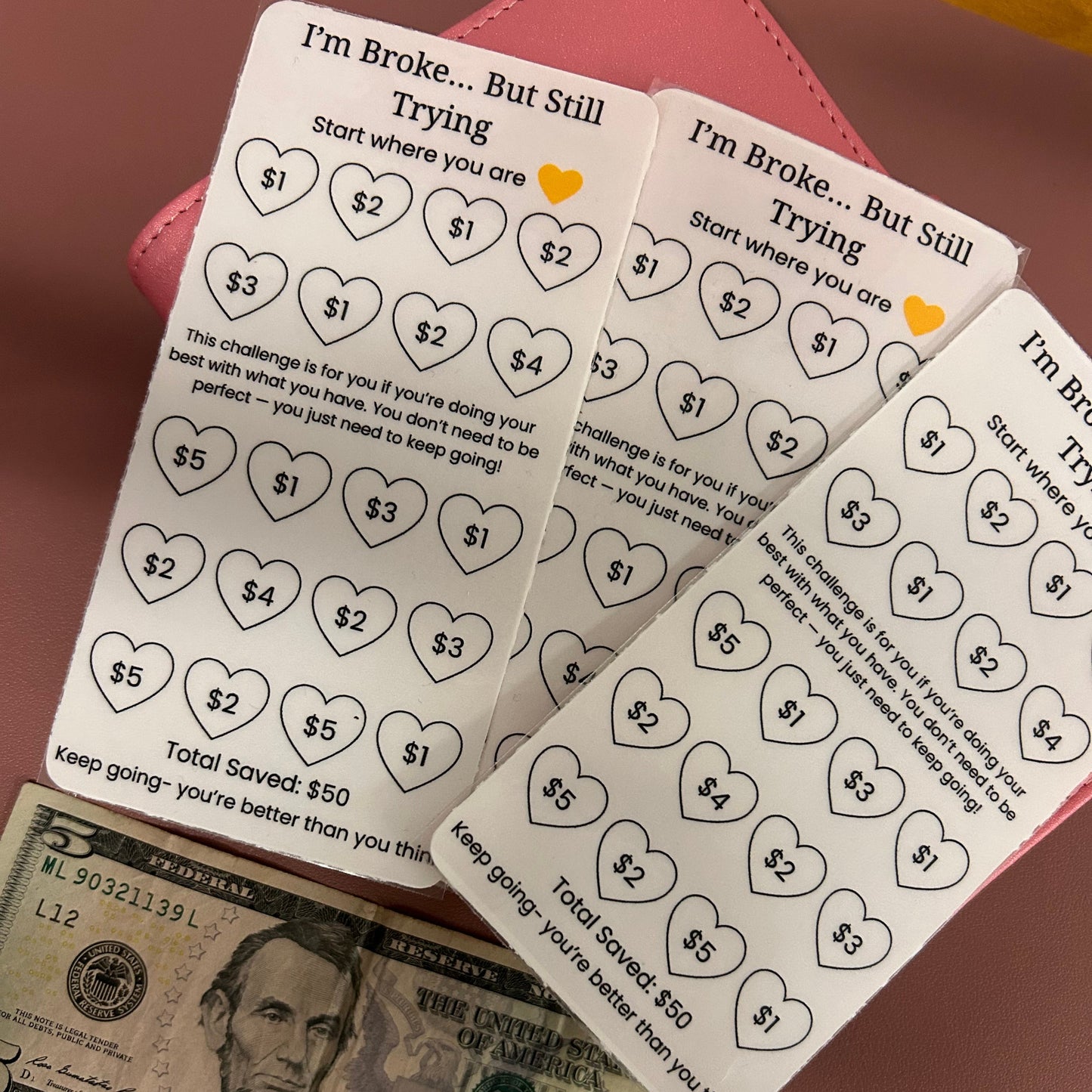 Savings challenges with heart designs and dollar bills on a pink surface