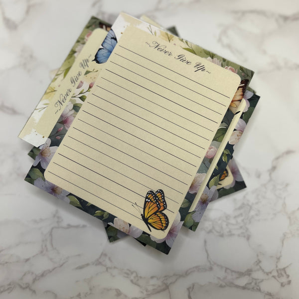 Set of decorative notepads with butterfly designs on a marble surface