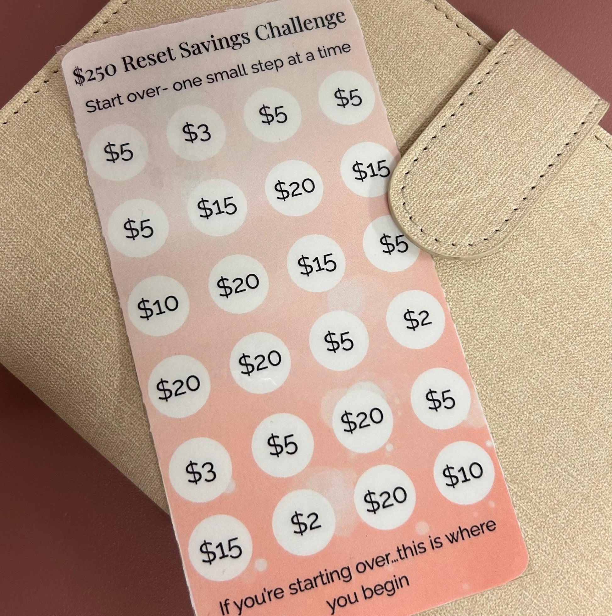 Reset Savings Challenge card with dollar amounts on a beige wallet against a brown background