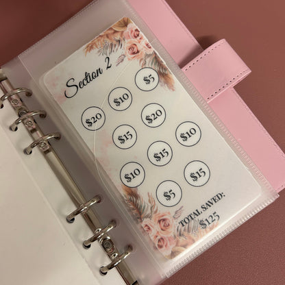 Pink planner with floral design and circular stickers on a matching pink background
