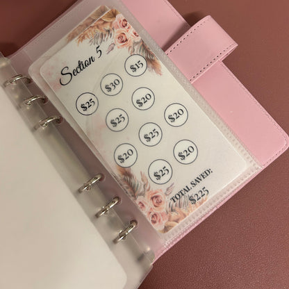 Pink planner with a card featuring floral designs and text on a matching pink background