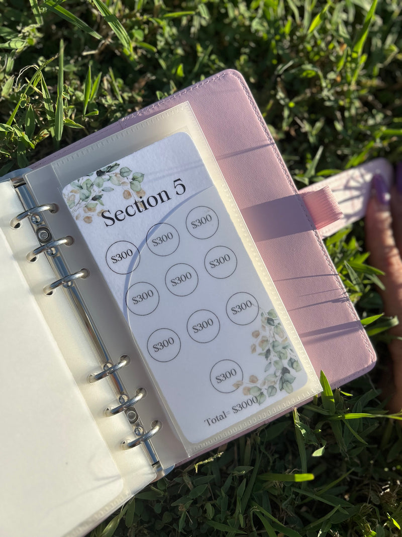 Planner with money tracking sheet on grass