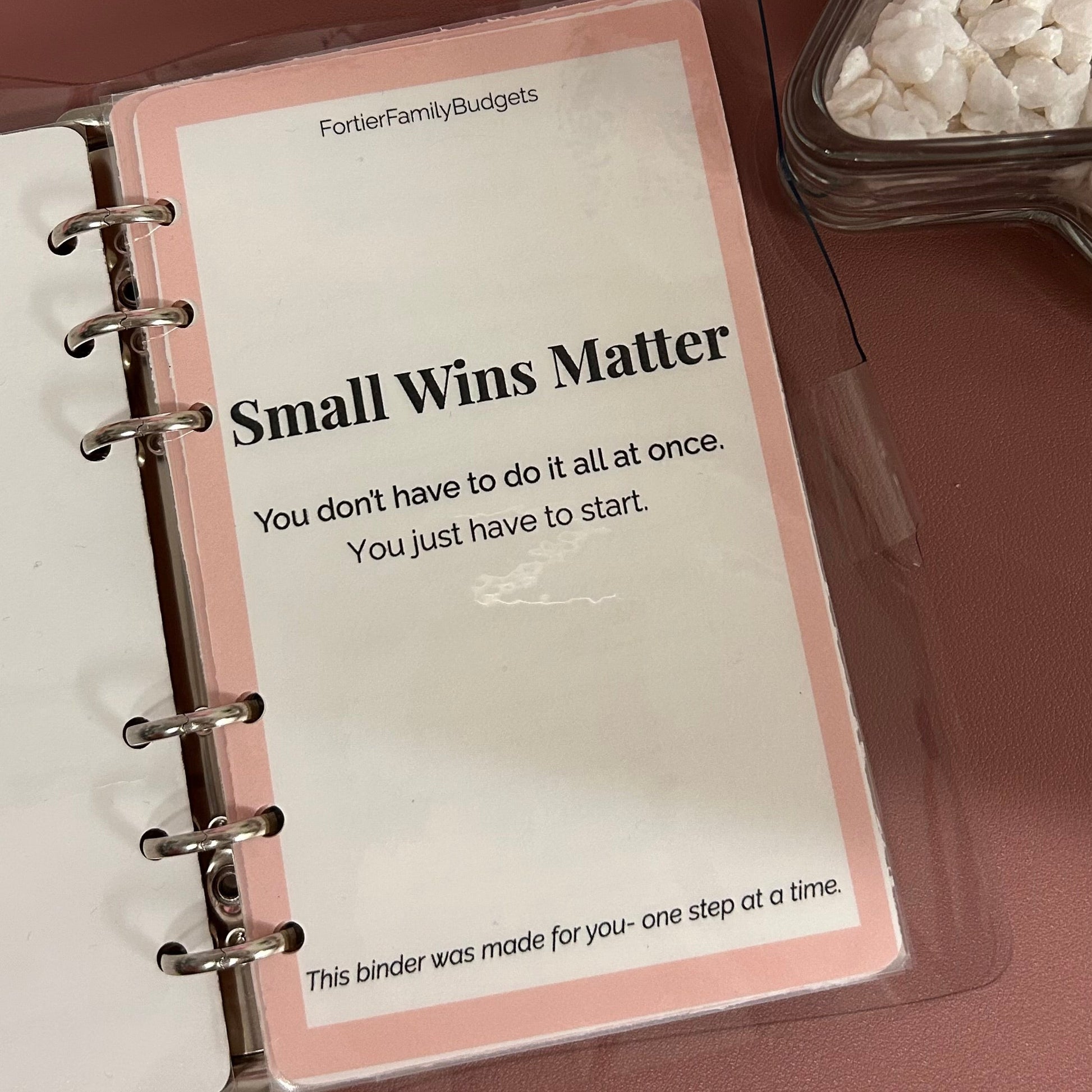 Open planner with a motivational quote on a wooden surface