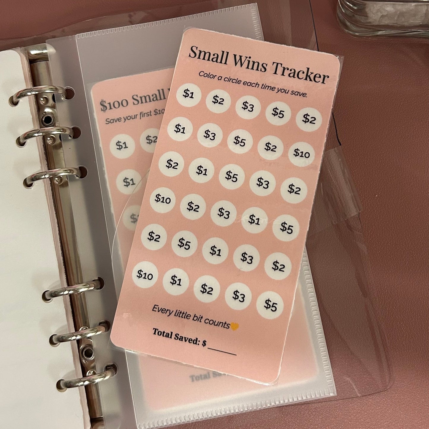 Small Wins Tracker card on a planner with a pink background