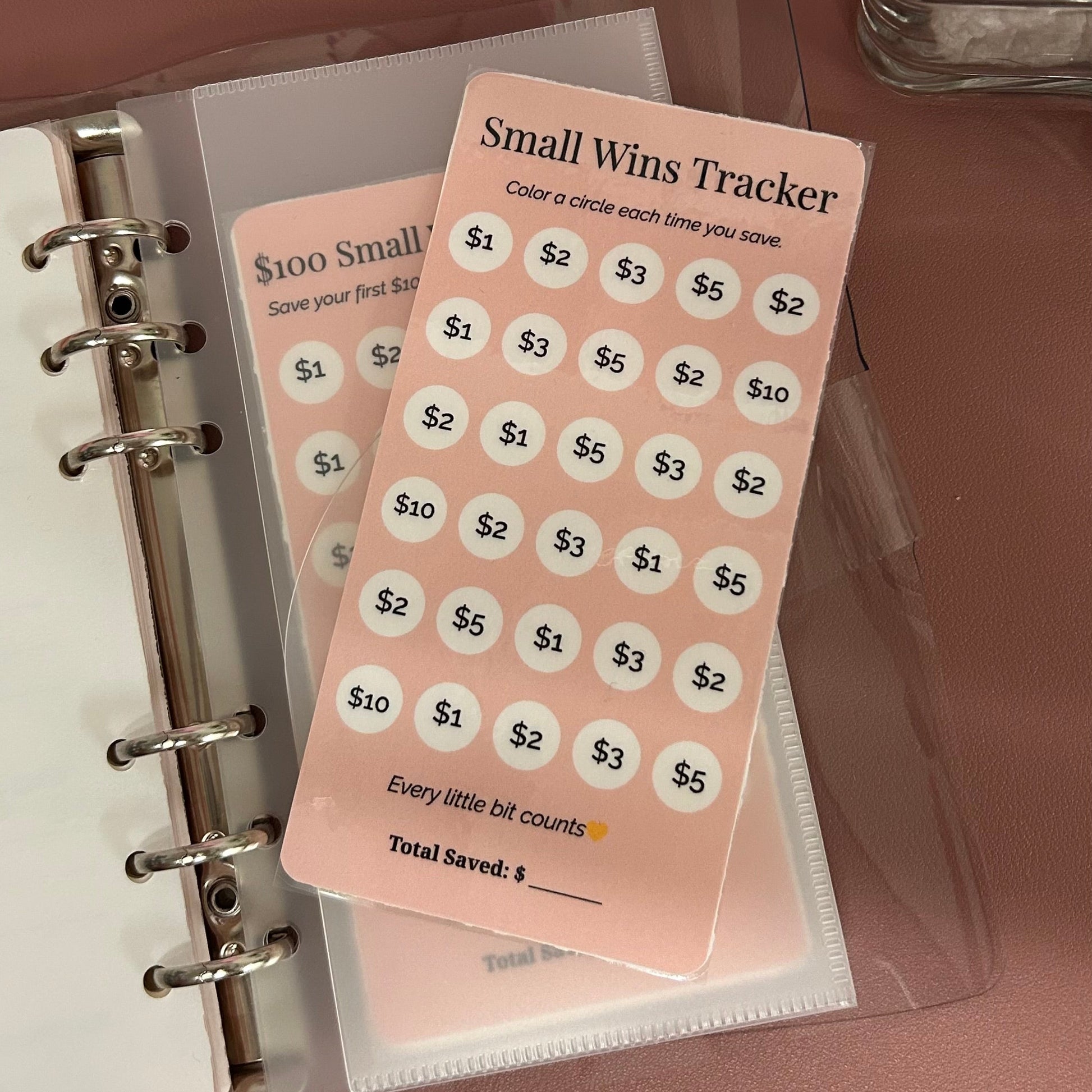 Small Wins Tracker card on a planner with a pink background