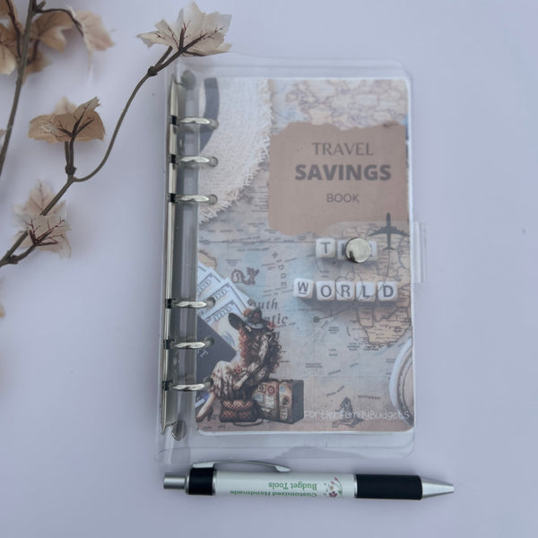Travel savings notebook with a pen on a light gray background