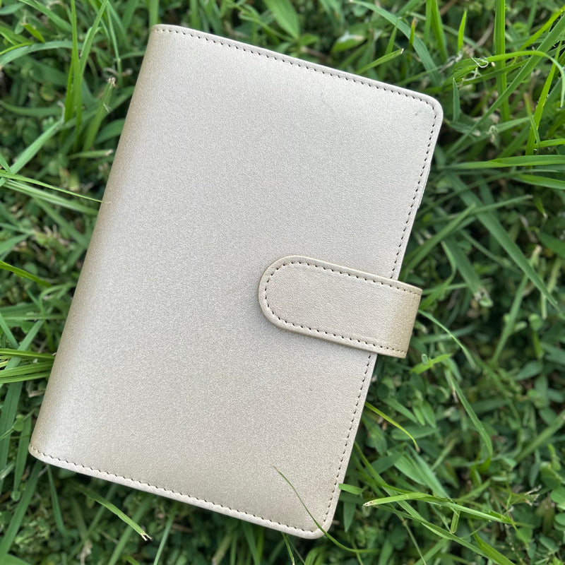 Light gray leather notebook on grass