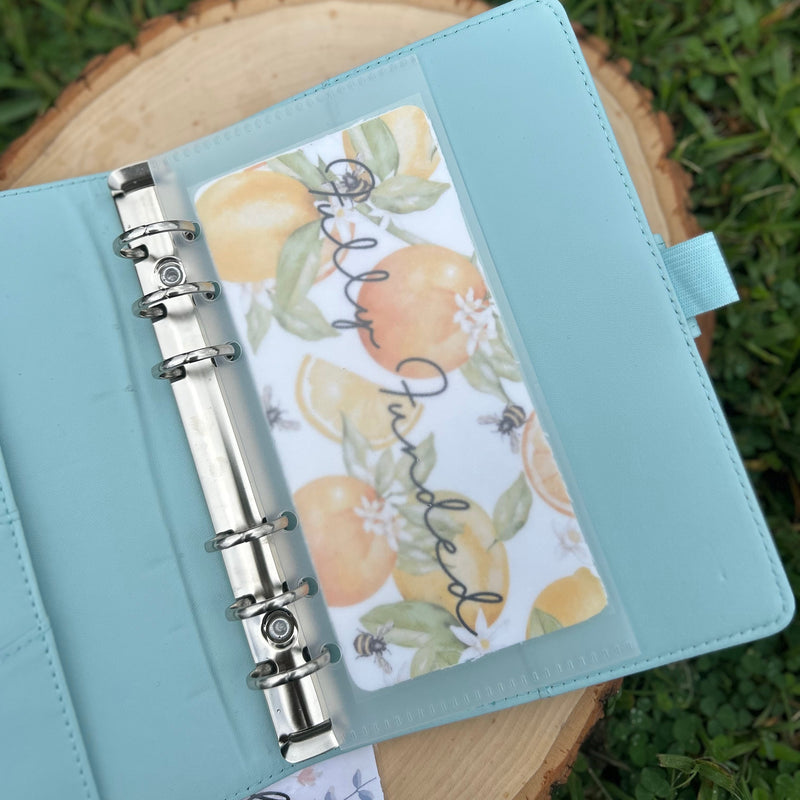 Light blue planner with floral design on a grassy background