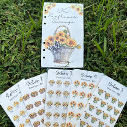 Set of sunflower-themed planner savings challenges on grass