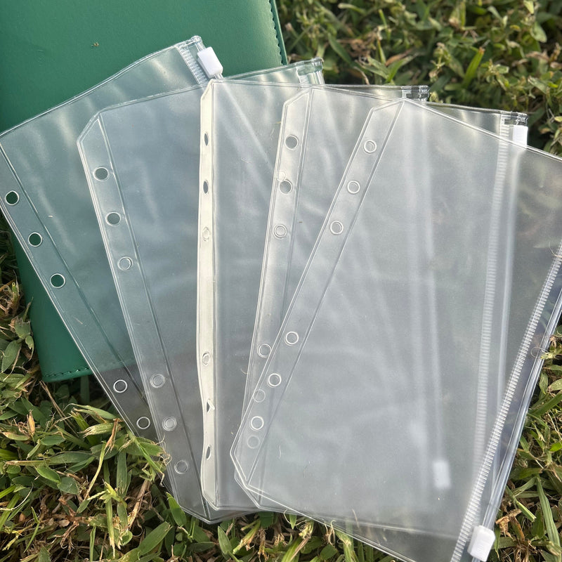 Clear plastic sleeves with holes on a grassy background