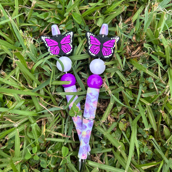 Butterfly-shaped hair accessories with purple and white design on grass