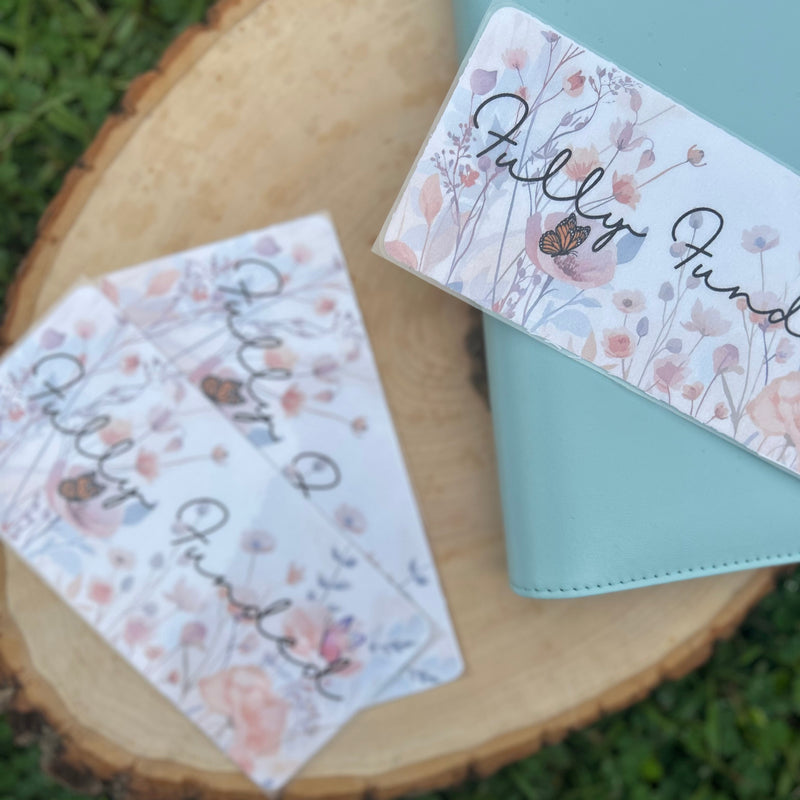 Floral cards with 'Fully Funded' text on a wooden surface with grass background