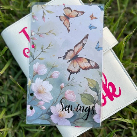 Notebook with butterfly and floral design on a grass background