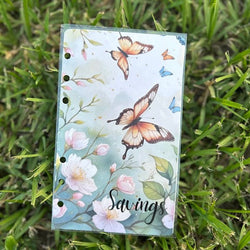 Notebook with butterfly and floral design on grass