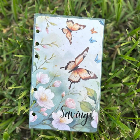 Notebook with butterfly and floral design on grass