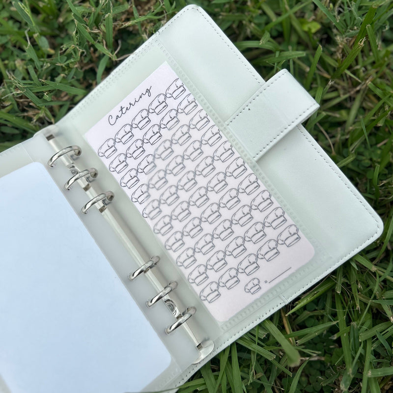 Open planner with stickers on grass