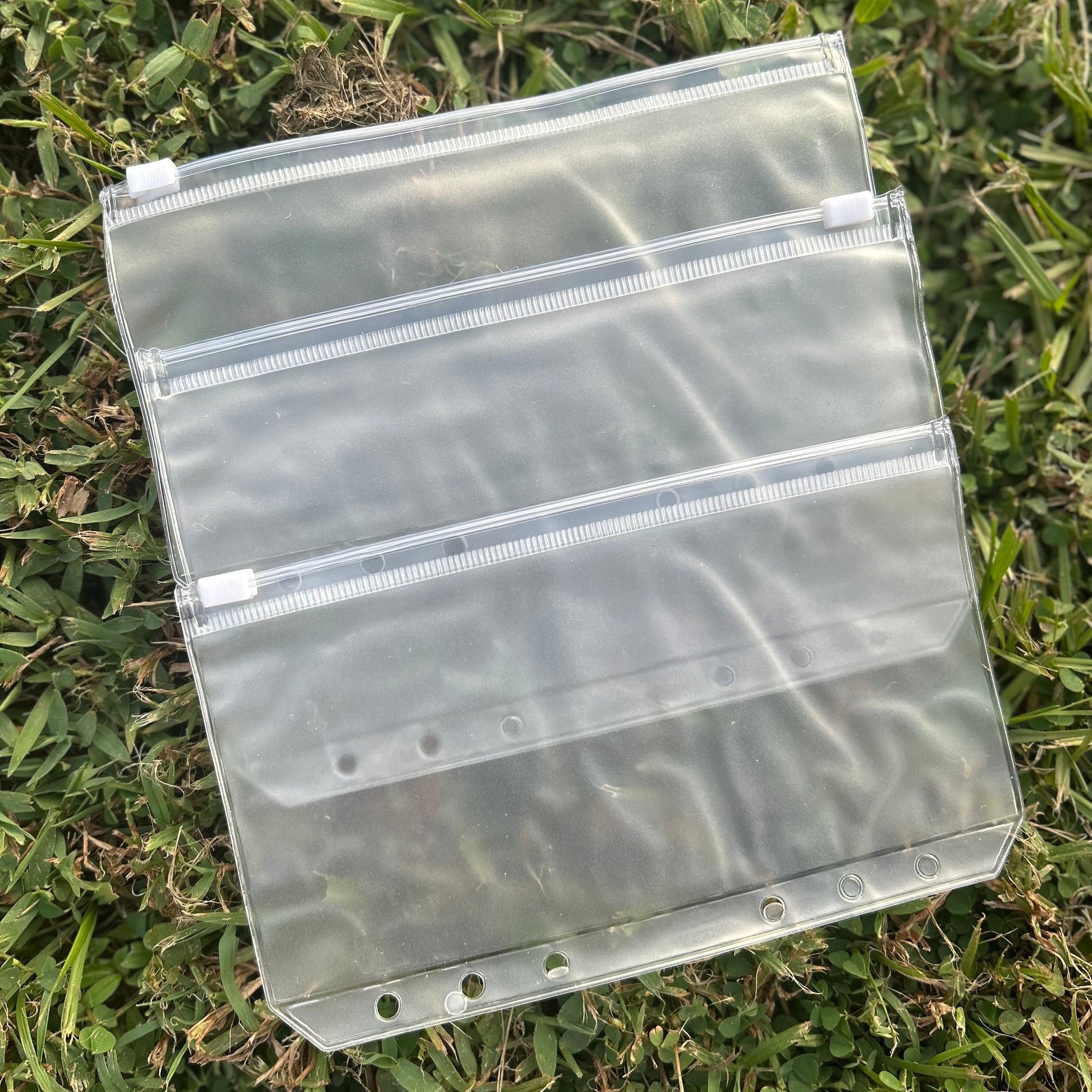 Clear plastic pouch with multiple compartments on grass
