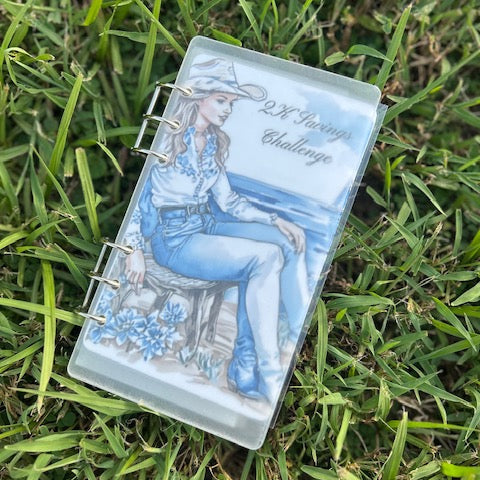 Notebook with a design of a woman in a cowboy hat and boots on grass