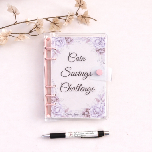 Notebook titled 'Coin Savings Challenge' with floral design on a light background