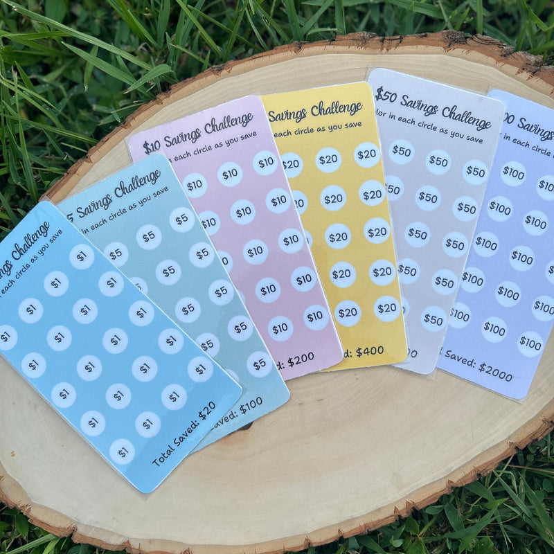 Set of savings challenge stickers on a wooden block with grass background