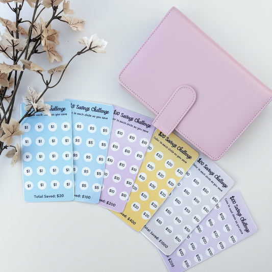 Set of savings challenge stickers with a pink organizer on a light blue background.