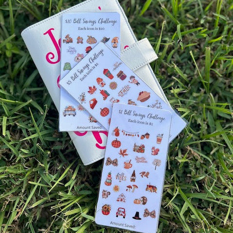 Three small books or cards with stickers on a grassy background