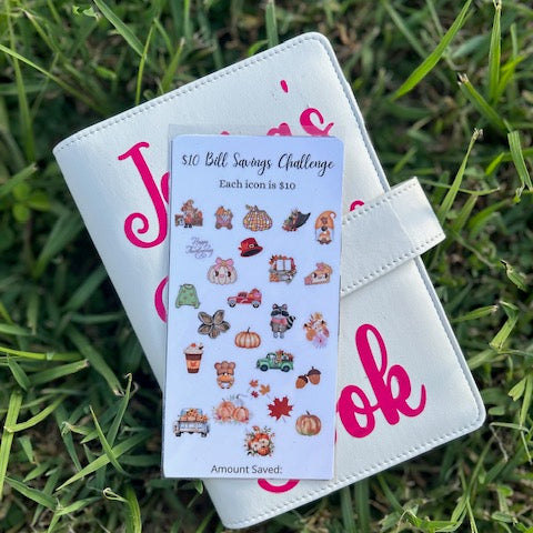 White planner with pink text on grass with fall savings challenge on binder