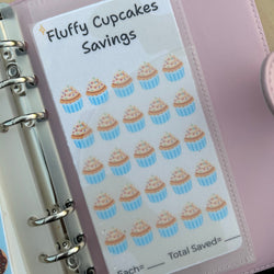 Planner with a sheet of cupcake-themed stickers labeled 'Fluffy Cupcakes Savings' on a pink planner cover.