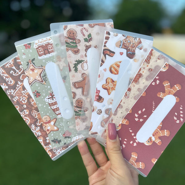 Hand holding a set of decorative cards with gingerbread-themed designs.
