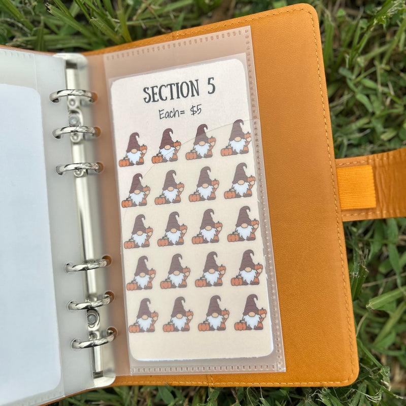 Notebook with a sheet of stickers featuring cartoon gnomes on grass